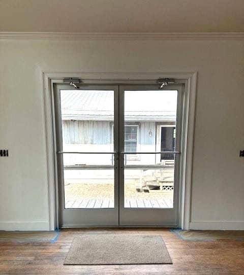 entryway with hardwood / wood-style floors, ornamental molding, and french doors