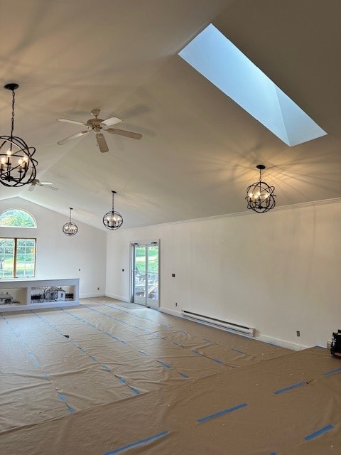 unfurnished living room featuring baseboard heating, ceiling fan, vaulted ceiling with skylight, and a healthy amount of sunlight