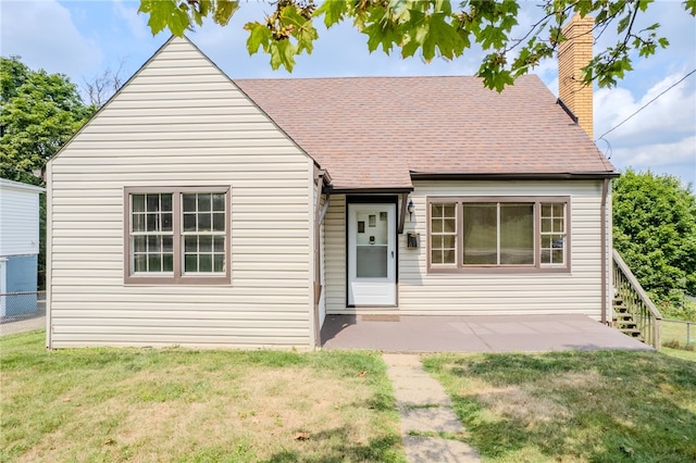 view of front of home with a patio and a front yard