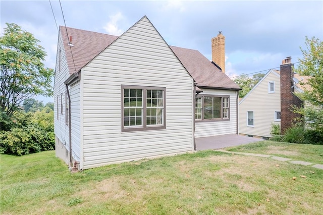 rear view of house featuring a lawn