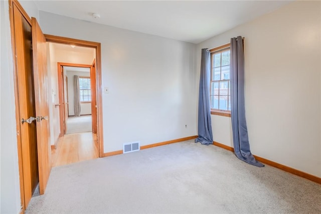 empty room with light carpet and a wealth of natural light