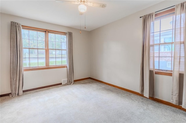 spare room with ceiling fan and light colored carpet