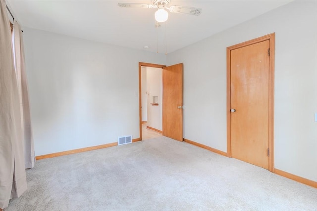 unfurnished bedroom featuring light colored carpet and ceiling fan