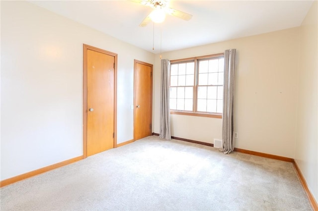 interior space featuring ceiling fan and light colored carpet