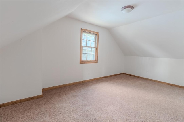 bonus room with carpet flooring and vaulted ceiling