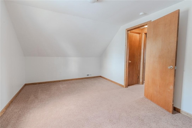 bonus room with light carpet and vaulted ceiling