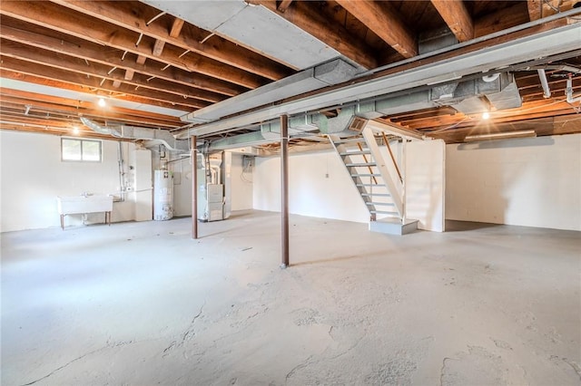 basement featuring heating unit, sink, and gas water heater