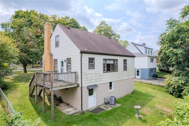 rear view of property with central AC unit, a yard, and a wooden deck