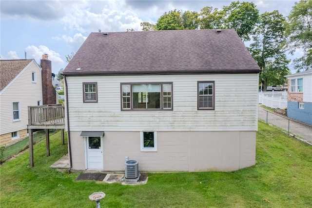 rear view of property featuring central AC, a deck, and a lawn