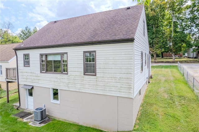 view of property exterior featuring a lawn and cooling unit