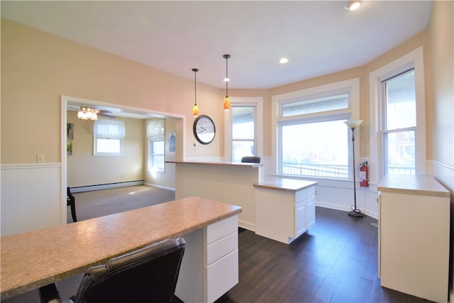 kitchen featuring a baseboard heating unit, a kitchen island, white cabinetry, hanging light fixtures, and dark hardwood / wood-style flooring