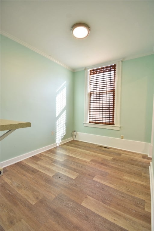 unfurnished room with crown molding and hardwood / wood-style flooring