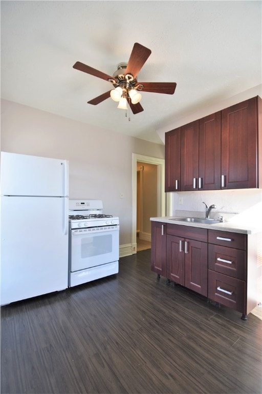 kitchen with dark wood-type flooring, white appliances, ceiling fan, and sink