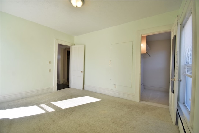 carpeted empty room featuring a baseboard radiator