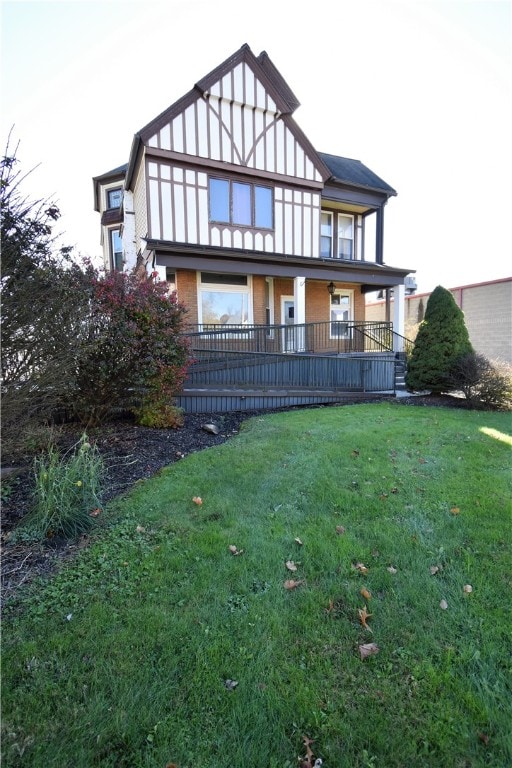 back of house with covered porch and a lawn