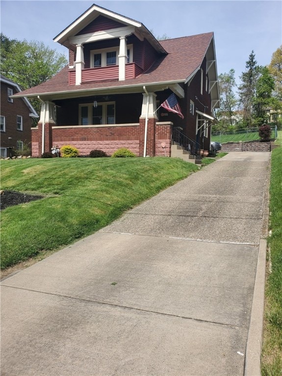 view of front of home with a porch and a front yard