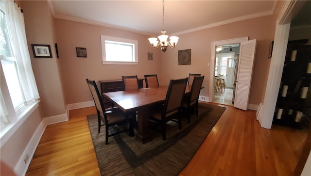 dining space with ornamental molding and light hardwood / wood-style floors