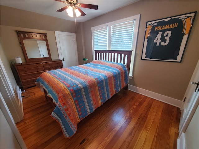 bedroom with dark hardwood / wood-style flooring and ceiling fan