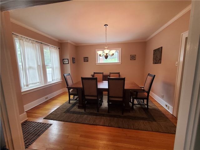 dining room featuring hardwood / wood-style flooring, crown molding, and a notable chandelier