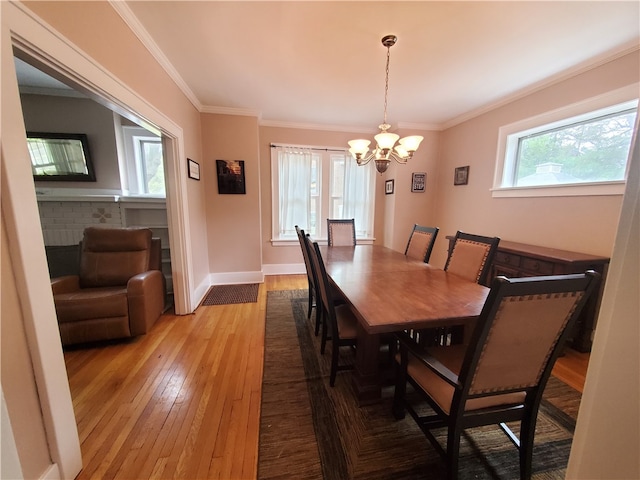 dining space with crown molding, a chandelier, hardwood / wood-style floors, and a wealth of natural light