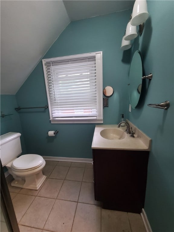 bathroom featuring vanity, lofted ceiling, tile patterned floors, and toilet