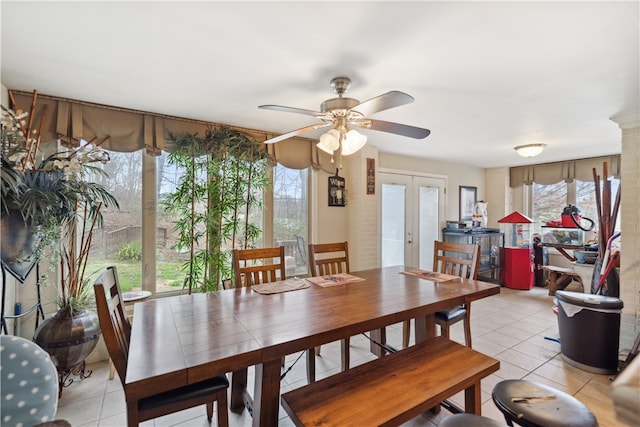 tiled dining room with ceiling fan and french doors