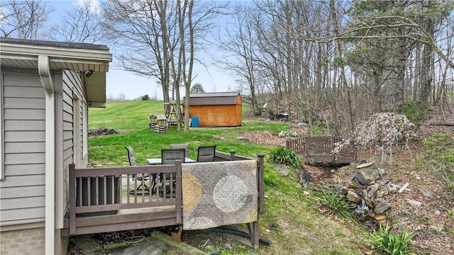 view of yard featuring a wooden deck and a storage shed