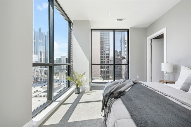 bedroom with floor to ceiling windows, carpet, and multiple windows