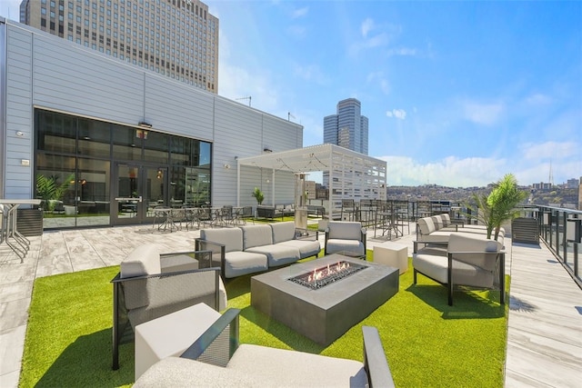 view of patio with an outdoor living space with a fire pit