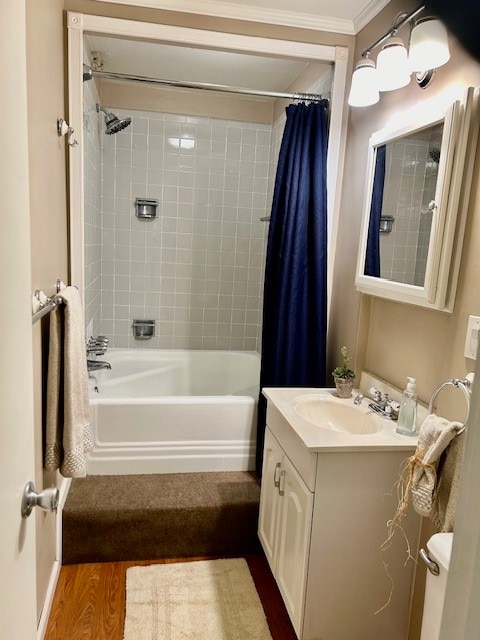 full bathroom featuring crown molding, shower / bath combination with curtain, vanity, hardwood / wood-style flooring, and toilet