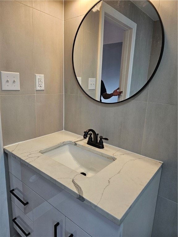 bathroom featuring vanity and tile walls