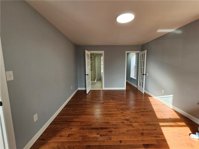 empty room with wood-type flooring and french doors