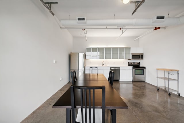 dining area with a towering ceiling and sink