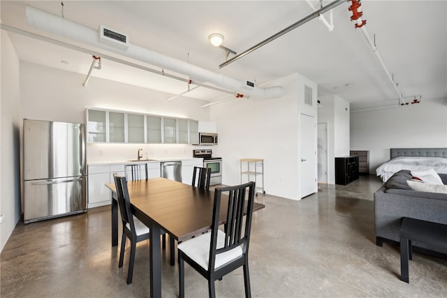 dining space featuring concrete flooring and sink