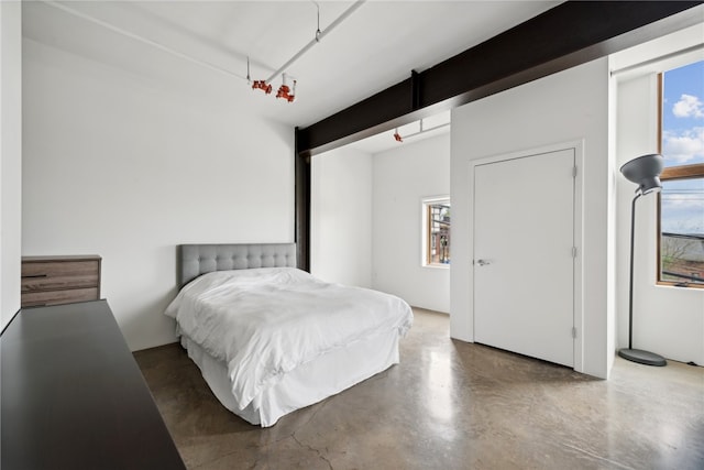 bedroom featuring multiple windows and concrete flooring