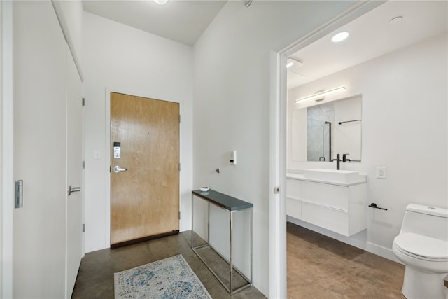 interior space with toilet, concrete floors, and vanity