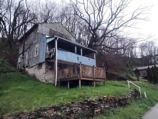 back of property with a lawn and a wooden deck