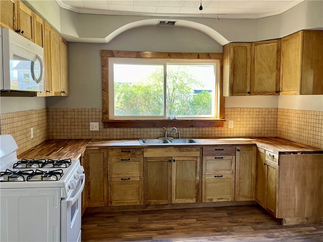 kitchen with decorative backsplash, butcher block counters, dark wood-type flooring, sink, and white appliances