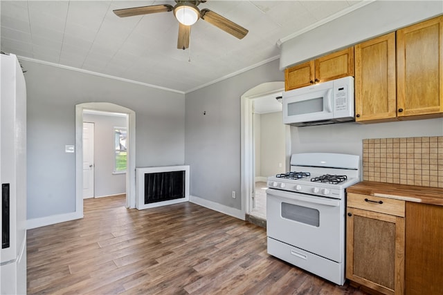 kitchen featuring white appliances, ceiling fan, ornamental molding, and dark hardwood / wood-style flooring