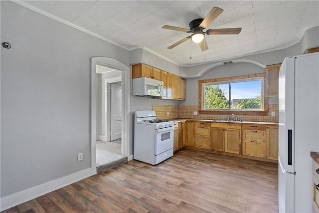 kitchen featuring white appliances, backsplash, ornamental molding, and light wood-type flooring