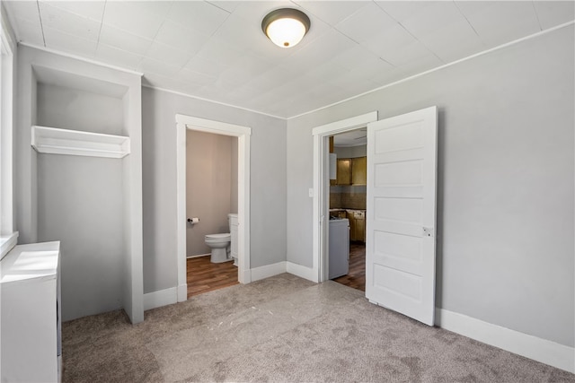 unfurnished bedroom featuring ensuite bathroom and light colored carpet