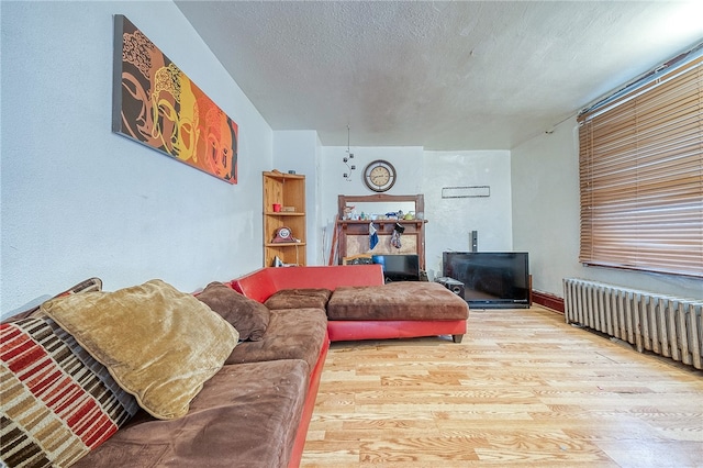 living room featuring a textured ceiling, radiator heating unit, and hardwood / wood-style floors