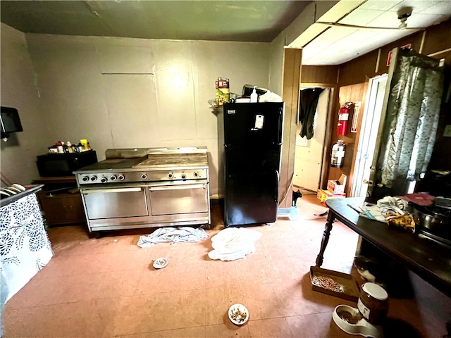 kitchen with tile floors and black fridge