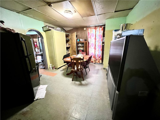 tiled dining space with a paneled ceiling