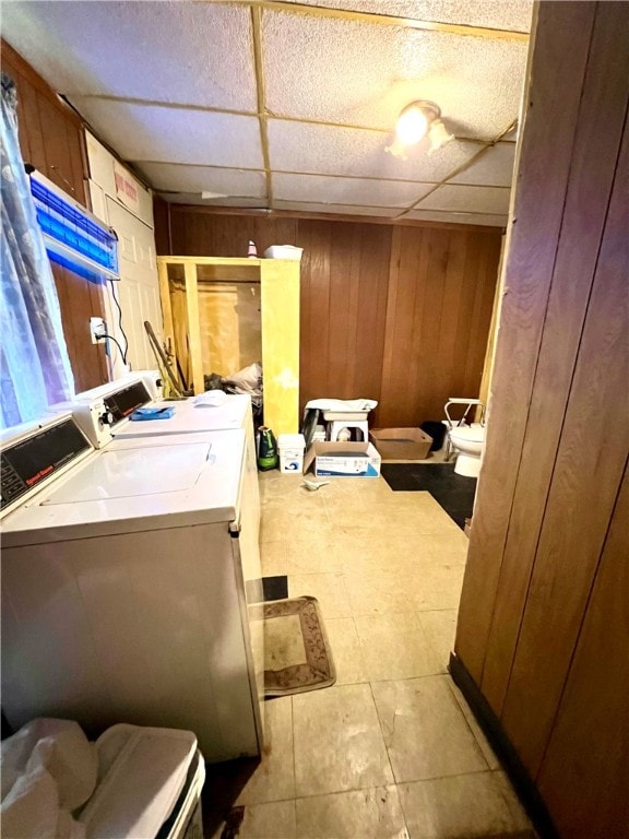 bathroom featuring wooden walls, oversized vanity, a paneled ceiling, and washing machine and clothes dryer