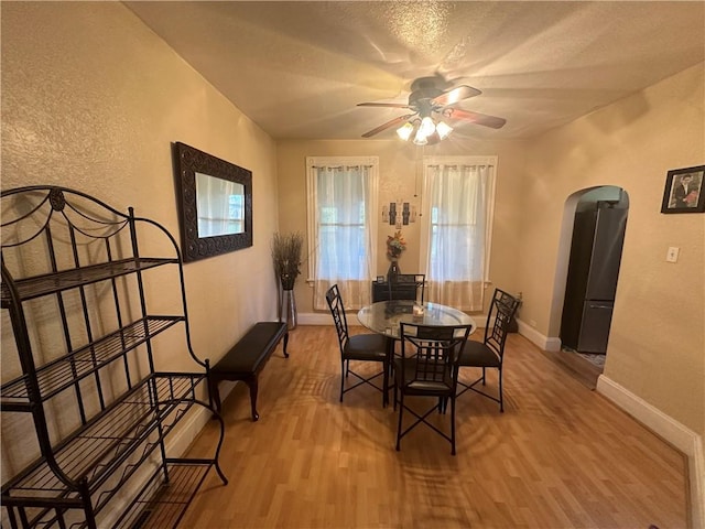 dining room featuring a textured ceiling, light wood-type flooring, and ceiling fan