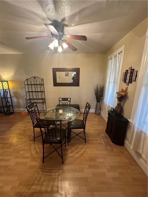 dining room featuring hardwood / wood-style floors, a textured ceiling, and ceiling fan