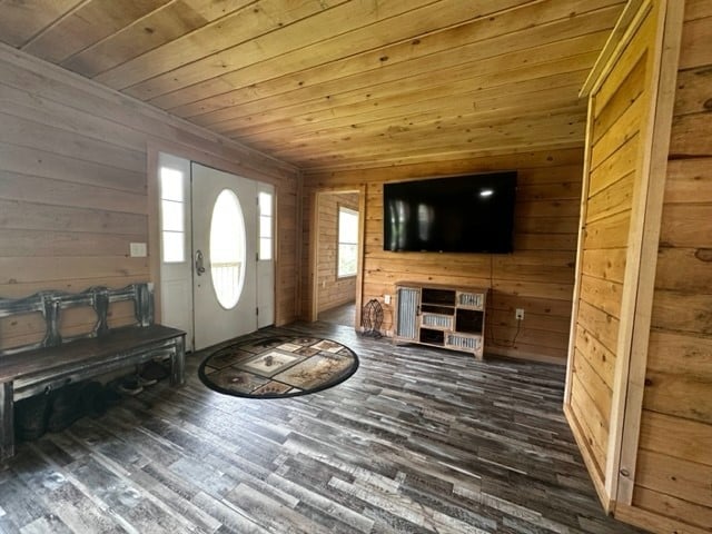 foyer entrance with wooden walls, dark hardwood / wood-style flooring, and wooden ceiling