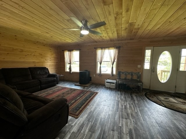 living room with wood walls, a healthy amount of sunlight, dark wood-type flooring, and wooden ceiling