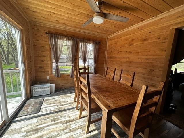 dining space featuring wooden ceiling, plenty of natural light, hardwood / wood-style floors, and wooden walls